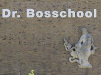 907268 Afbeelding van de tekst 'Dr. Bosschool' en de schoongemaakte natuurstenen wandsculptuur 'Maria' van René van ...